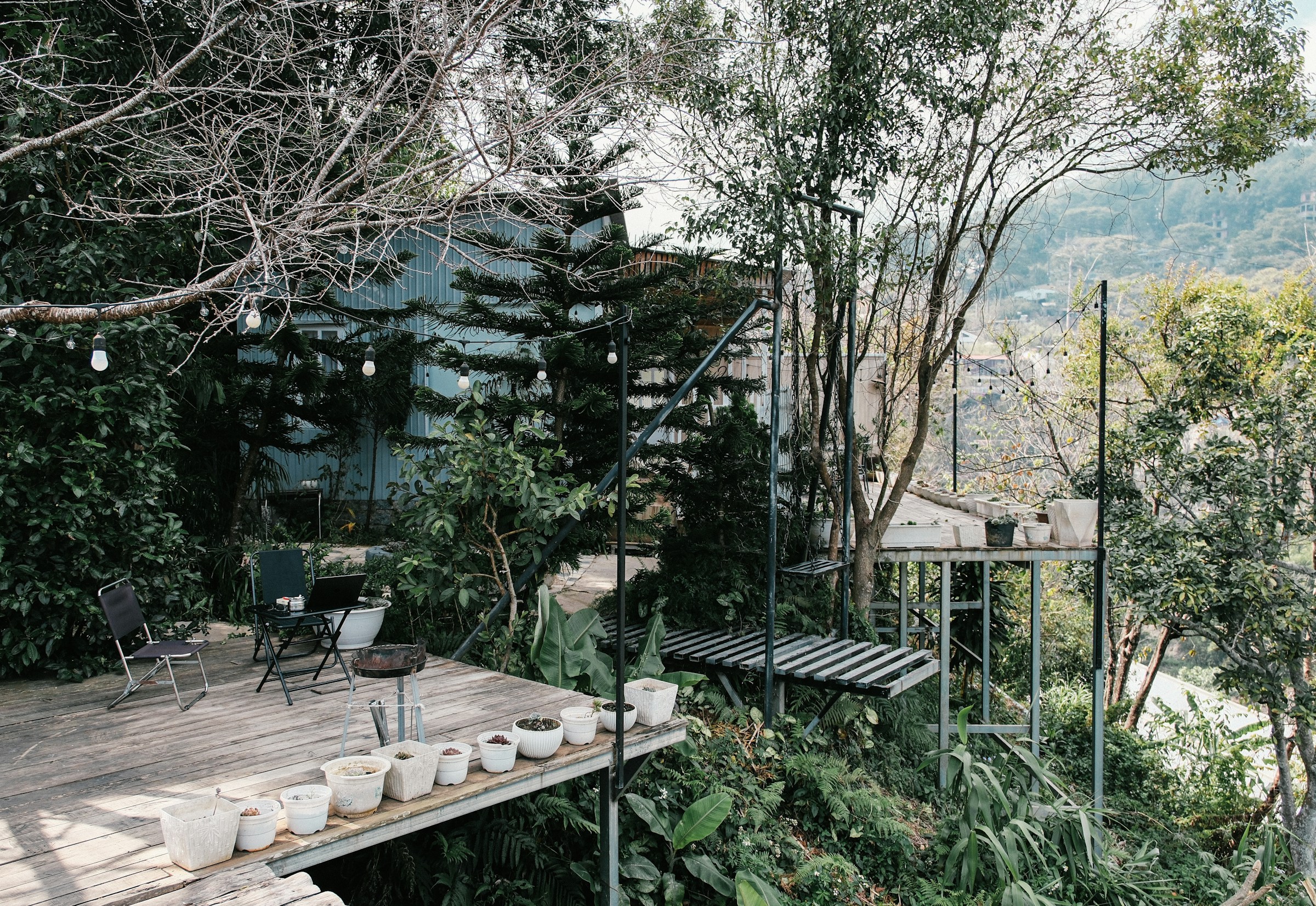 Terrasse en bois avec plantes en pot donnant sur un jardin